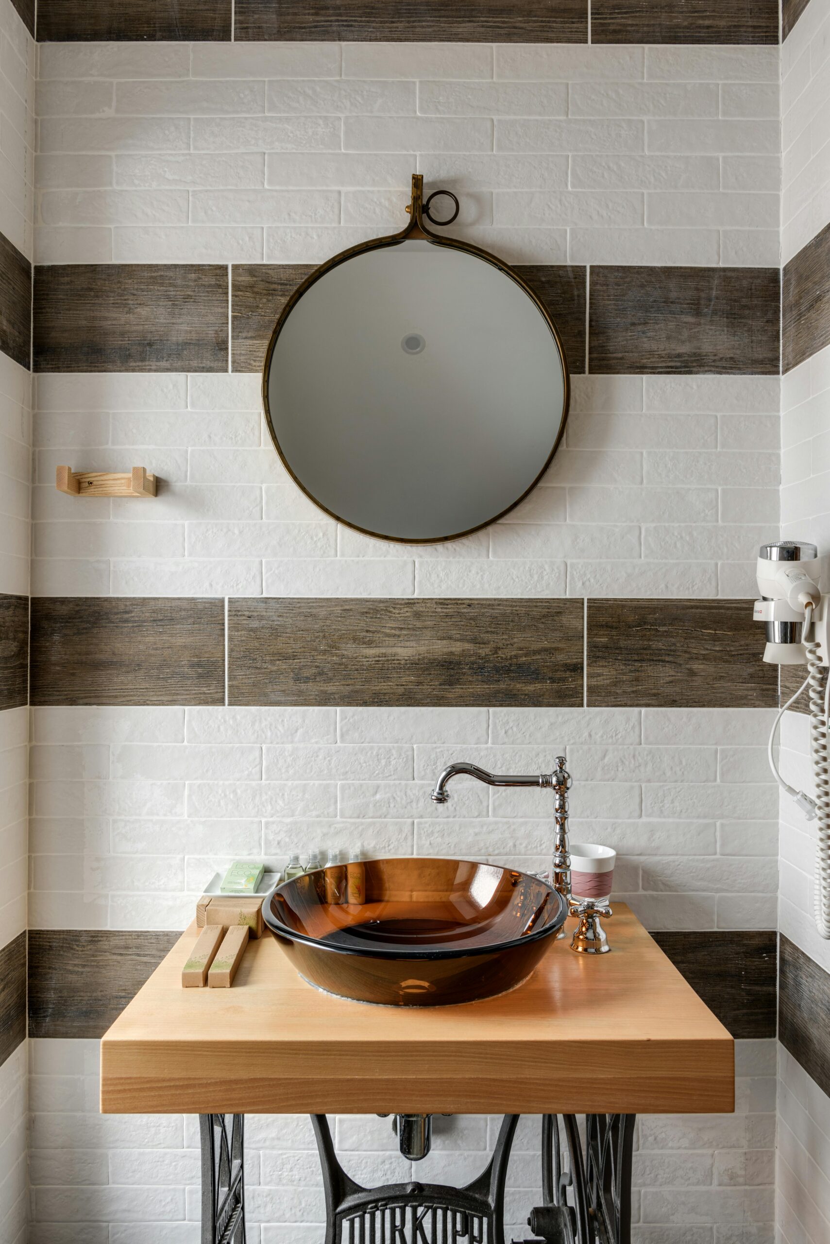 a bathroom with a round mirror and a sink